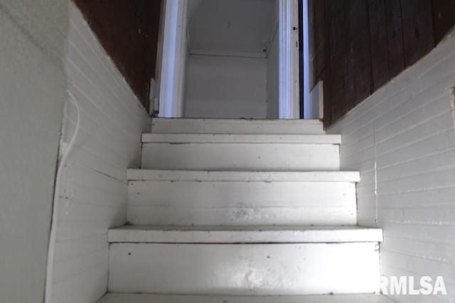 stairs featuring wooden walls