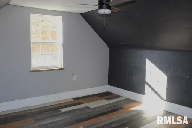 additional living space with dark hardwood / wood-style floors, vaulted ceiling, and ceiling fan