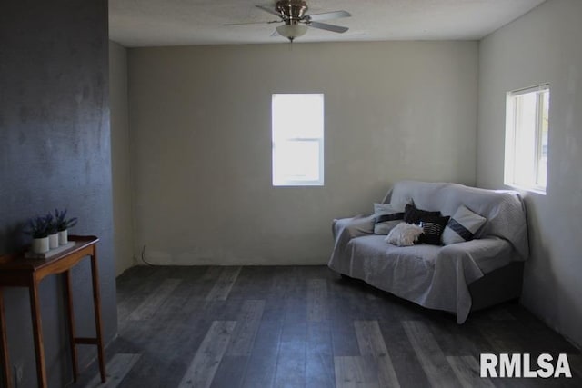 living area with ceiling fan and dark hardwood / wood-style flooring