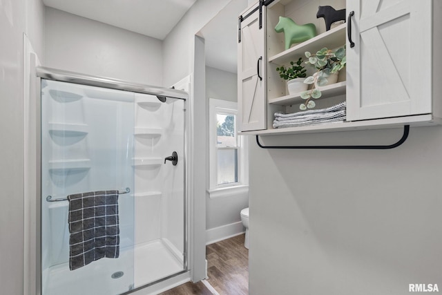 bathroom with hardwood / wood-style floors, toilet, and walk in shower