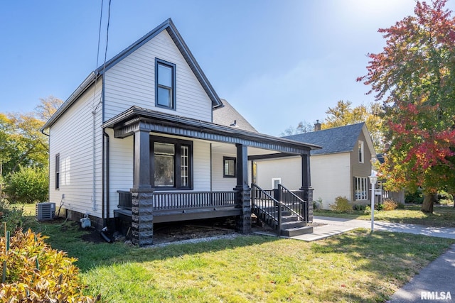 view of front of home featuring central AC unit, covered porch, and a front yard