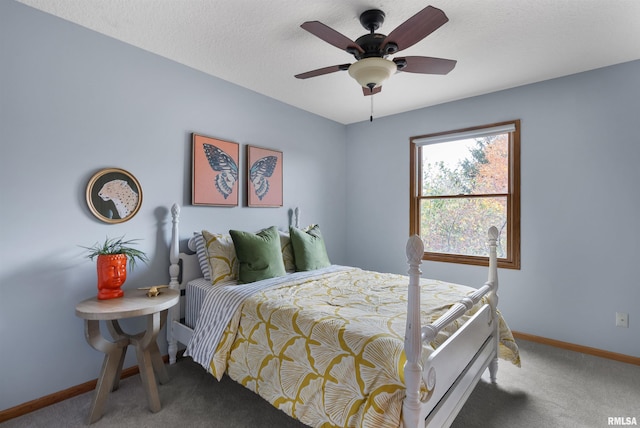 bedroom with ceiling fan, carpet floors, and a textured ceiling