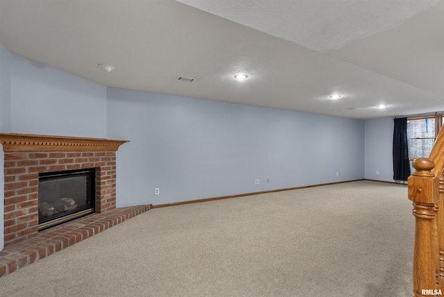 unfurnished living room featuring carpet floors and a brick fireplace