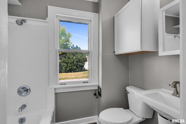 full bathroom with toilet, sink,  shower combination, and a wealth of natural light