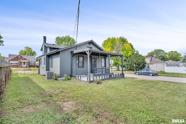 bungalow featuring a front lawn, covered porch, and central AC unit