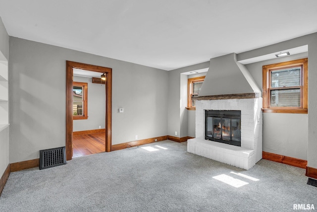 unfurnished living room featuring carpet floors and a fireplace