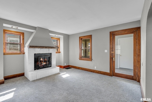 unfurnished living room with light carpet and a fireplace