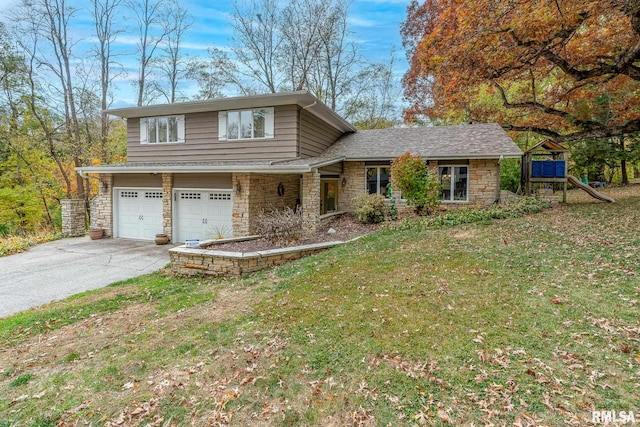 split level home featuring a front lawn, a garage, and a playground