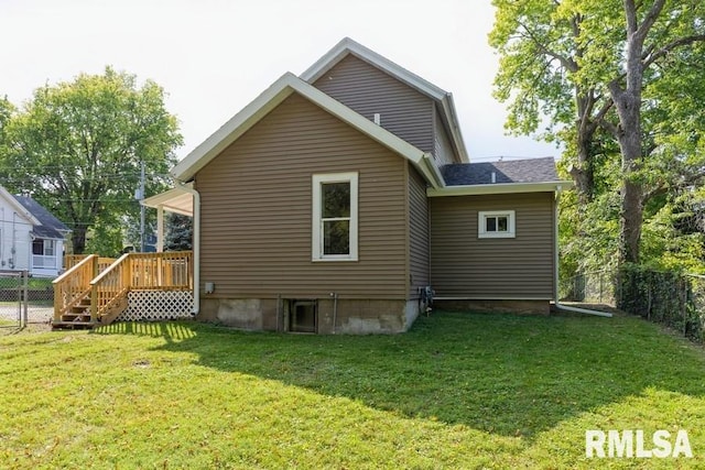 back of property with a wooden deck and a yard