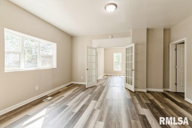 spare room with wood-type flooring and french doors