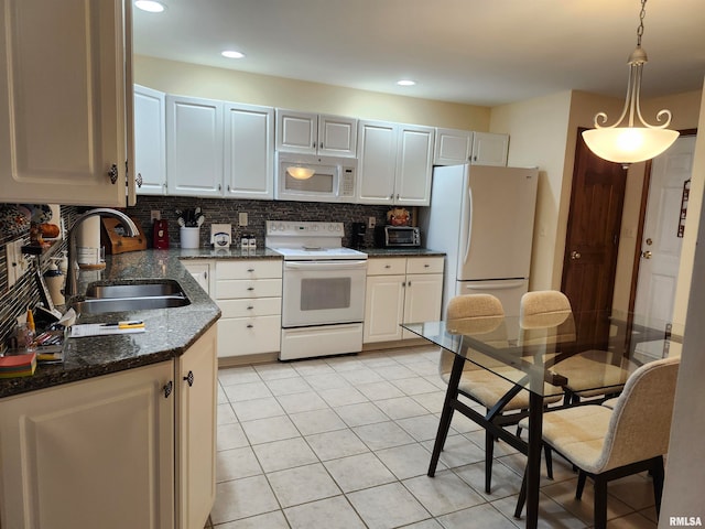 kitchen with white cabinets, hanging light fixtures, dark stone countertops, sink, and white appliances