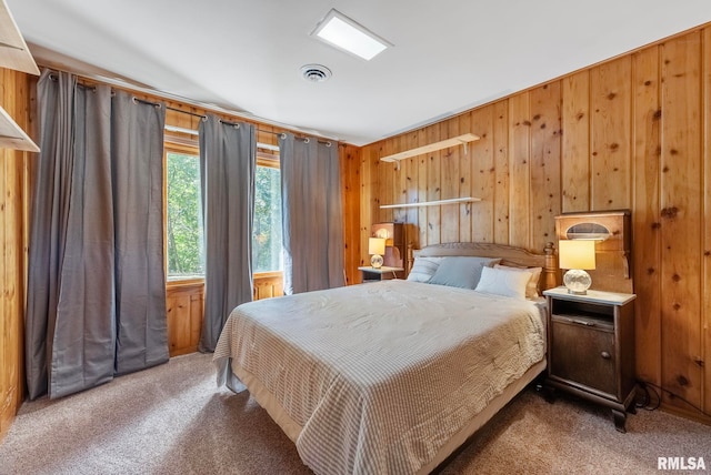 bedroom with wood walls and dark colored carpet