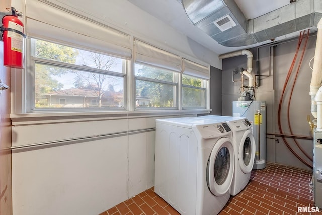 laundry room featuring washing machine and dryer and water heater