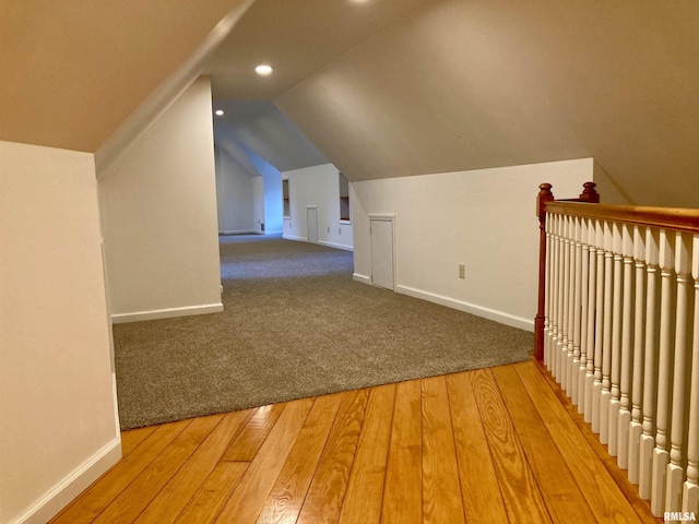 bonus room with wood-type flooring and vaulted ceiling