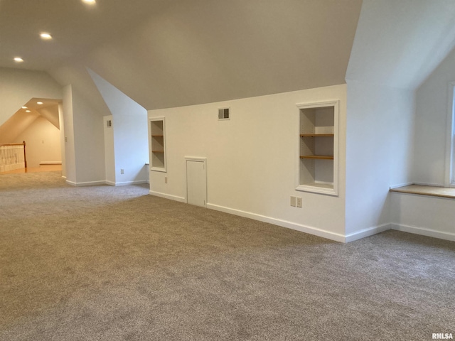 bonus room featuring built in shelves, lofted ceiling, and carpet floors