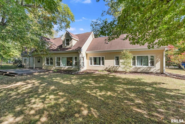 rear view of property with a lawn and a patio