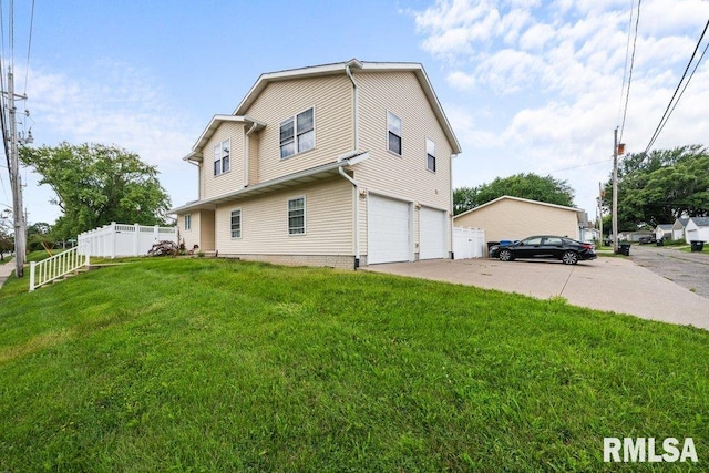 back of house with a garage, driveway, a lawn, and fence