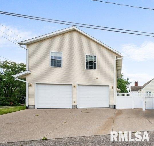 view of front of home with a garage and fence