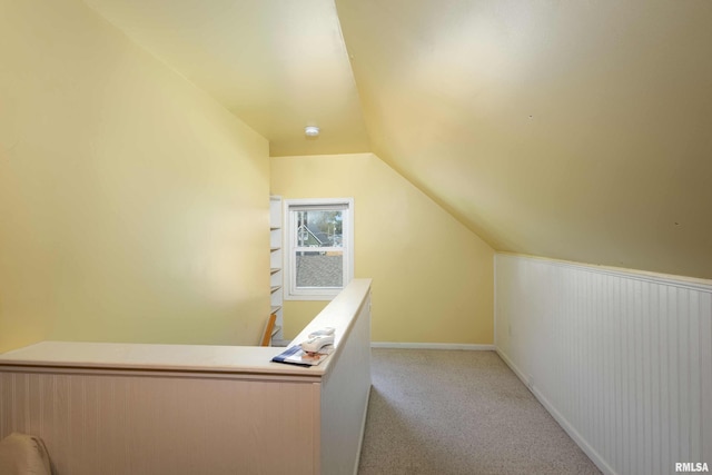 unfurnished office featuring light carpet and lofted ceiling