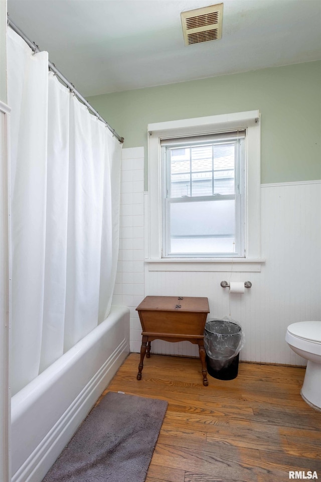 bathroom with toilet, shower / bath combination with curtain, and wood-type flooring