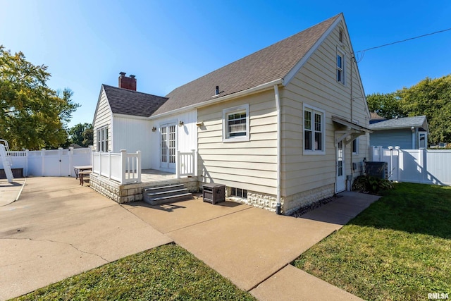 back of property with a patio area, french doors, and a lawn