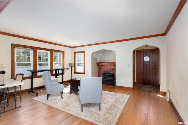 living room featuring light hardwood / wood-style floors, crown molding, and a fireplace