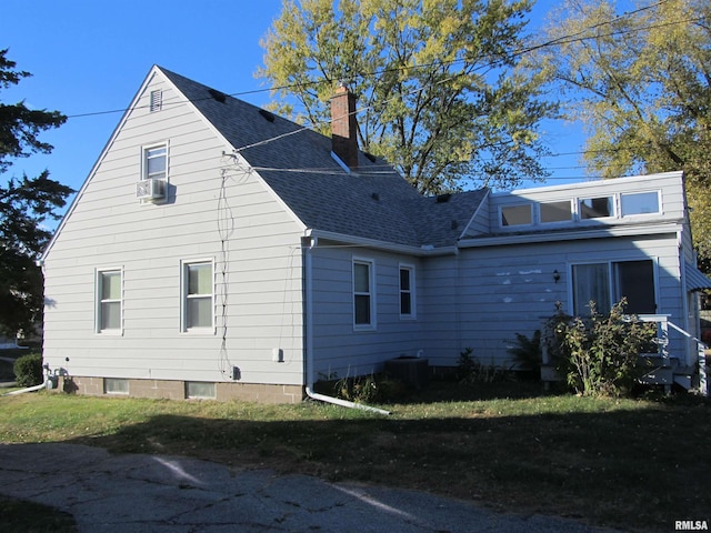 view of property exterior with central air condition unit, cooling unit, and a yard