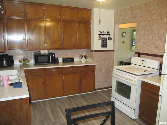 kitchen featuring dark wood-type flooring, white gas range, and sink