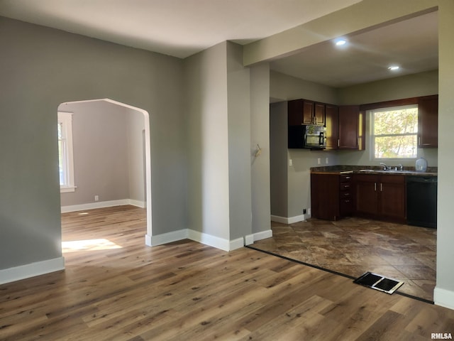 kitchen featuring dark brown cabinets, black appliances, sink, and hardwood / wood-style floors