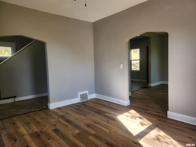 unfurnished room with dark wood-type flooring and plenty of natural light