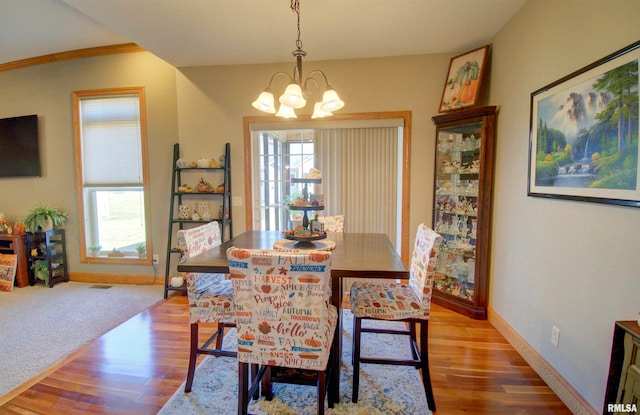 dining space with an inviting chandelier, plenty of natural light, and hardwood / wood-style floors