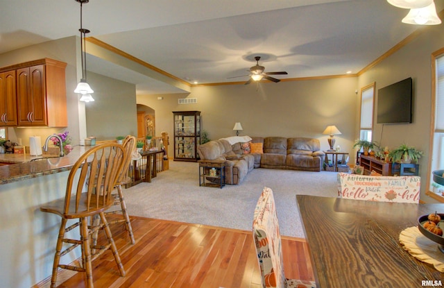 living room featuring ornamental molding, sink, light hardwood / wood-style flooring, and ceiling fan