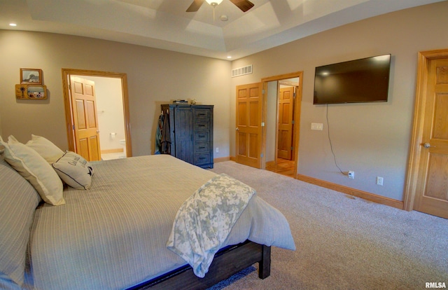 bedroom with connected bathroom, ceiling fan, and light colored carpet