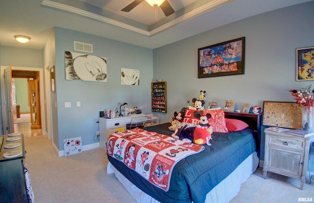 carpeted bedroom featuring a tray ceiling and ceiling fan