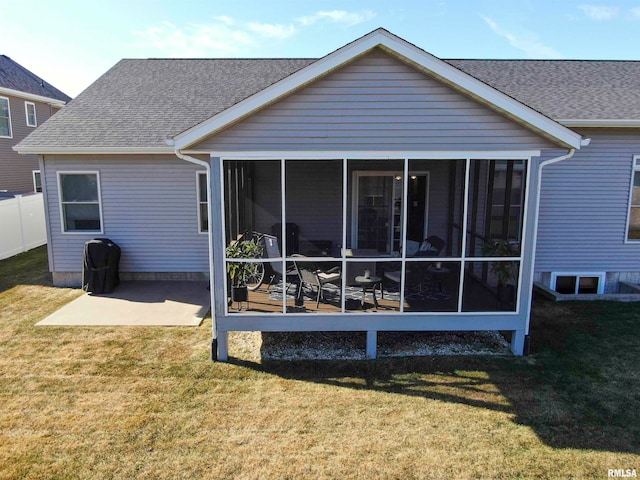 rear view of house featuring a yard and a sunroom