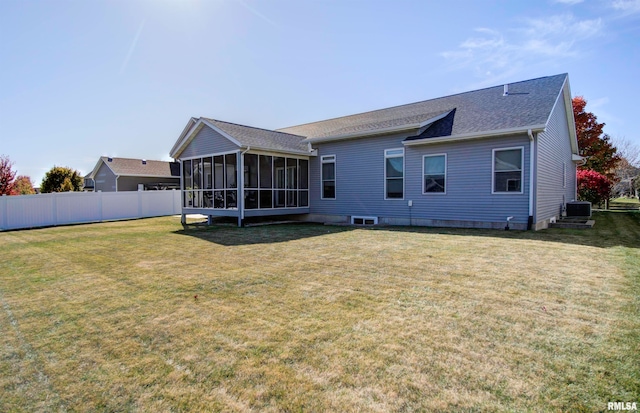 rear view of house featuring cooling unit, a lawn, and a sunroom