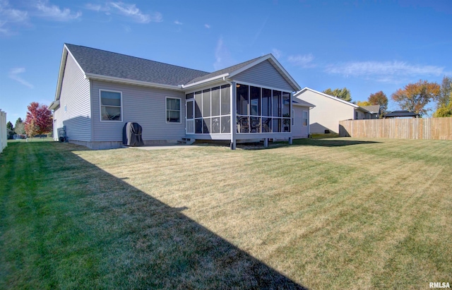 rear view of property with a sunroom and a lawn