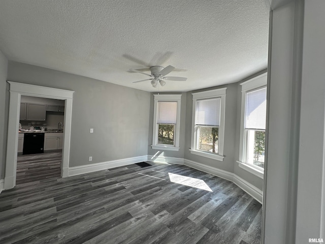 spare room with sink, ceiling fan, a textured ceiling, and dark hardwood / wood-style flooring