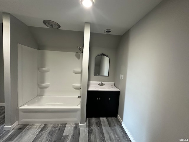 bathroom featuring vanity, washtub / shower combination, and hardwood / wood-style flooring