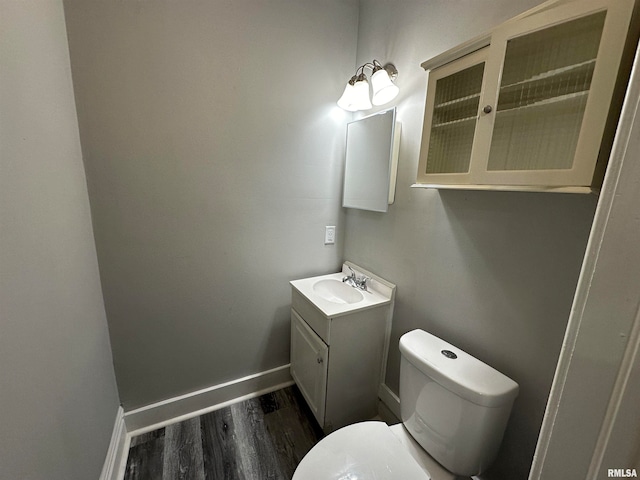 bathroom with vanity, toilet, and wood-type flooring