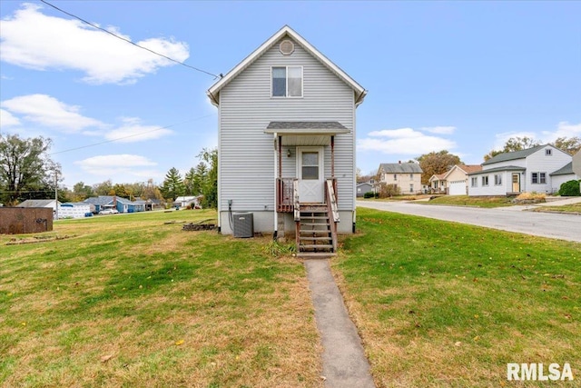 view of front of house featuring a front yard and central AC