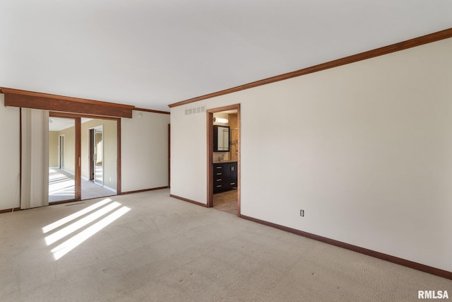 carpeted spare room featuring crown molding