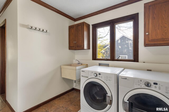 clothes washing area featuring dark tile patterned flooring, independent washer and dryer, sink, crown molding, and cabinets