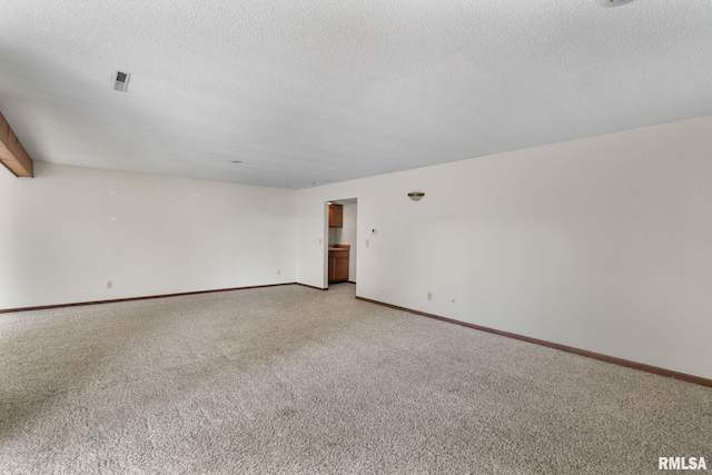 spare room featuring carpet and a textured ceiling