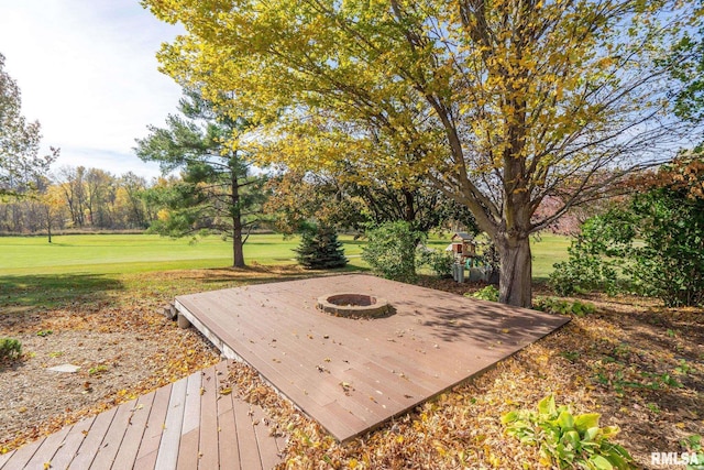 wooden terrace featuring a yard and an outdoor fire pit