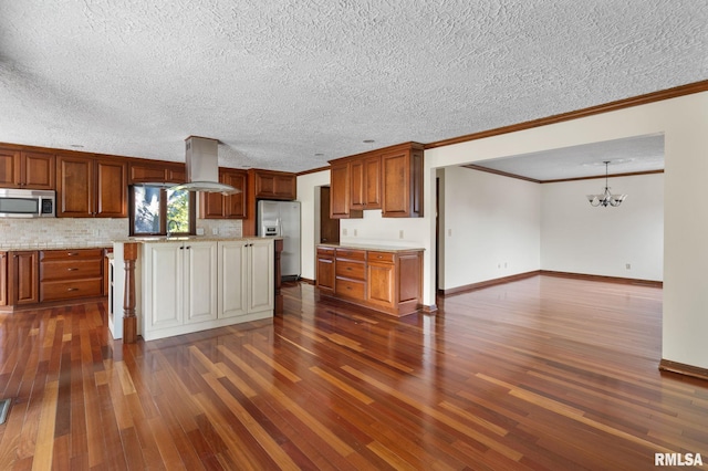 kitchen featuring appliances with stainless steel finishes, island range hood, a textured ceiling, crown molding, and dark hardwood / wood-style floors