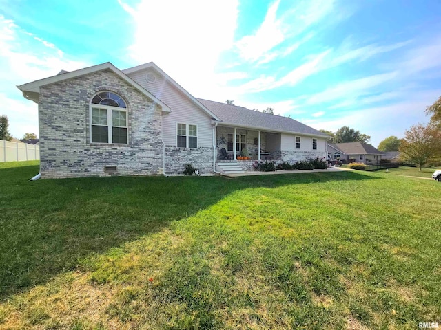 rear view of property featuring a yard