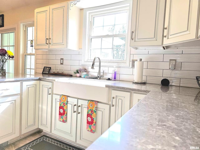 kitchen featuring sink, cream cabinetry, and tasteful backsplash