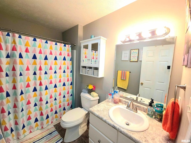 bathroom with vanity, a textured ceiling, toilet, and walk in shower