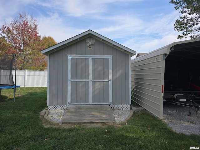 view of outdoor structure with a yard and a trampoline